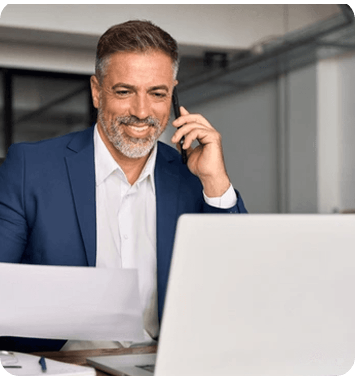 Business professional using phone and laptop